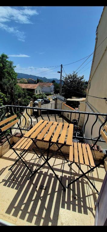 un banc en bois installé au-dessus d'une terrasse dans l'établissement Maisonnette rénovée avec cour, clim et métro à 5 min, à Marseille
