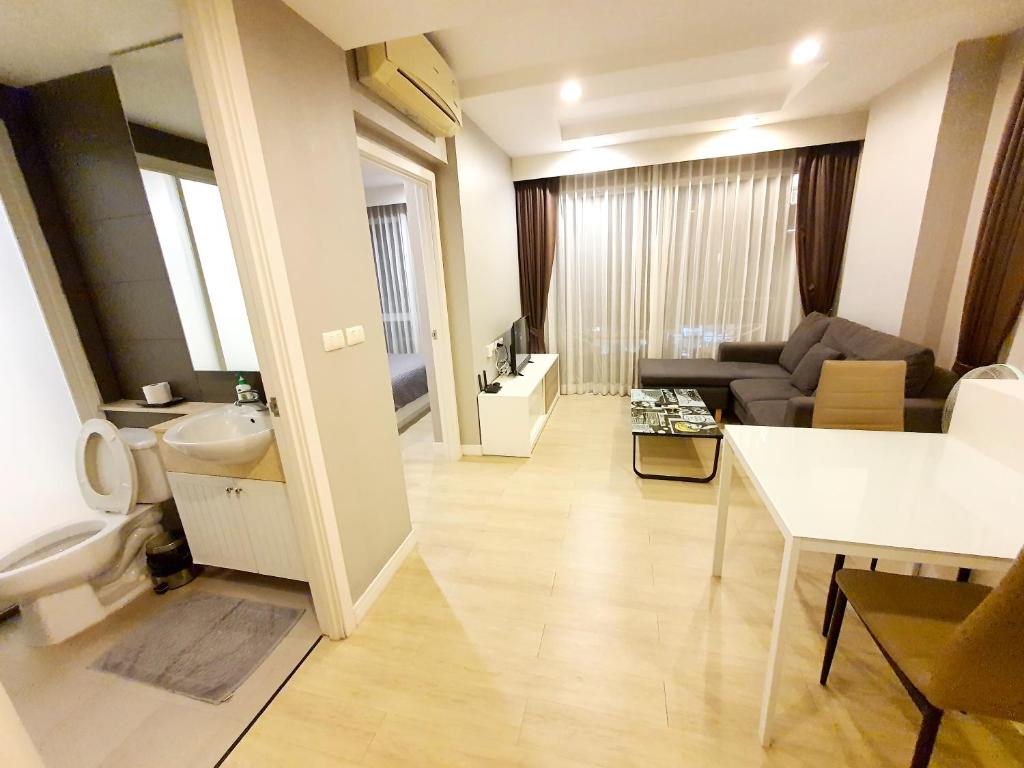 a bathroom with a sink and a living room at Chic 1BR near WON Beach Bangsaen in Ban Bang Saen (1)