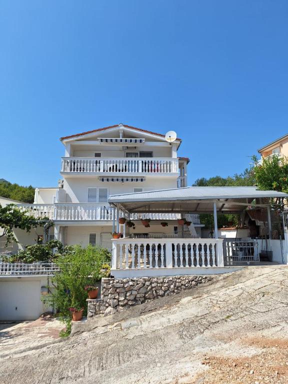 a large white house on top of a hill at Apartments Zdenka in Marina