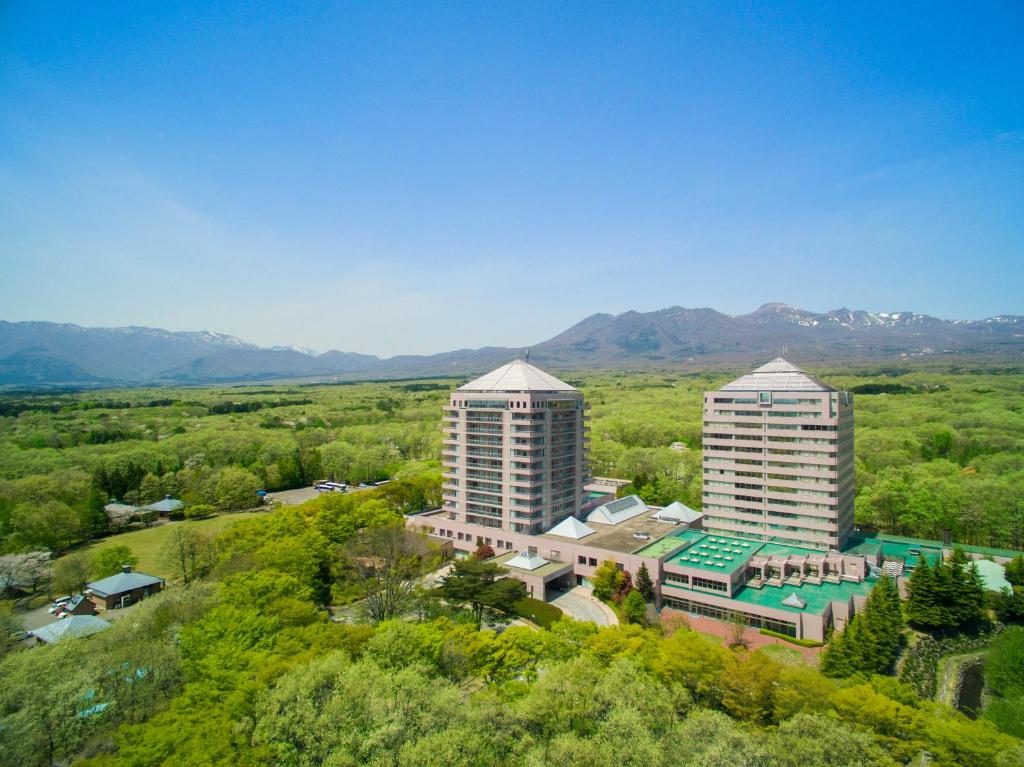 an overhead view of two tall buildings with mountains in the background at Hotel Epinard Nasu in Nasu