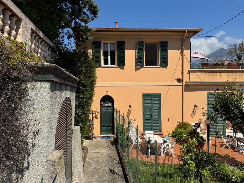 une maison avec des portes vertes et une clôture dans l'établissement Menton apartment with large terrace, à Menton