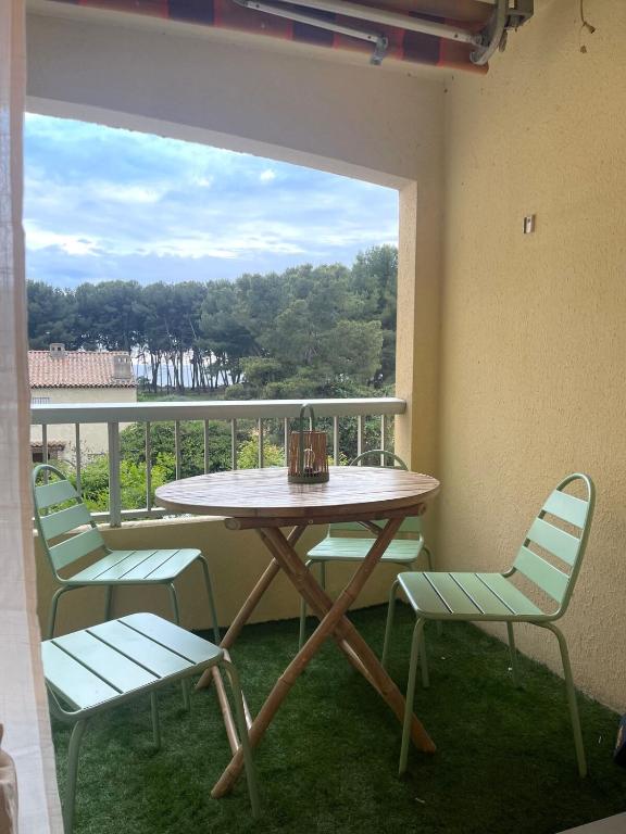 une table et des chaises sur un balcon avec vue dans l'établissement De la pinède a la plage vue mer, à Saint-Mandrier-sur-Mer