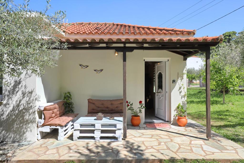 a patio in front of a house with a roof at Magnolia House Stafylos in Skopelos Town
