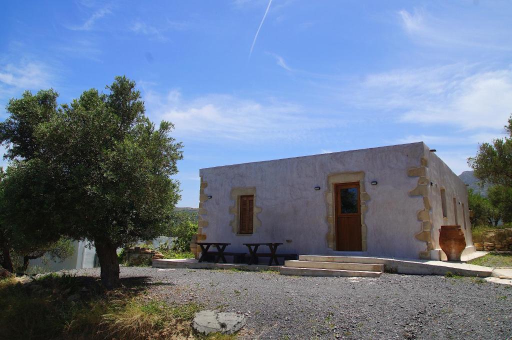 a small white building with a picnic table in front of it at The Village Hideaway - Traditional Stone House in Kissamos