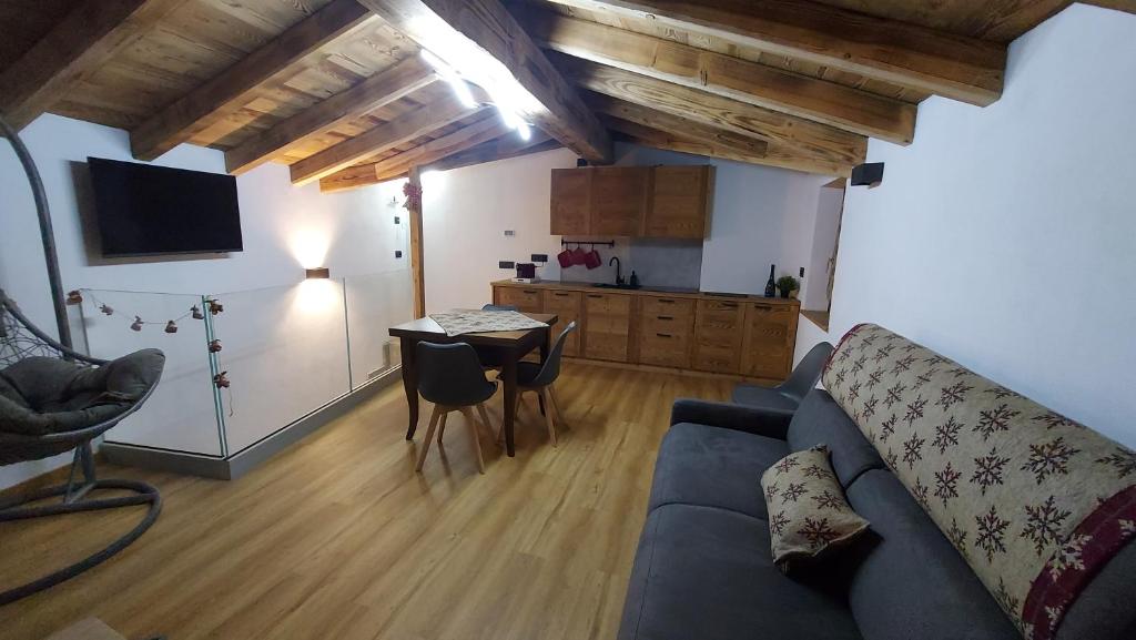 un soggiorno con un divano blu e un tavolo di CAV MES VALLEES La Thuile a La Thuile