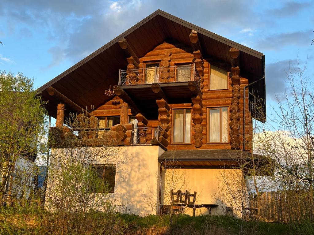 a log house with a balcony on top of it at Villa ZRUB in Palyanytsya