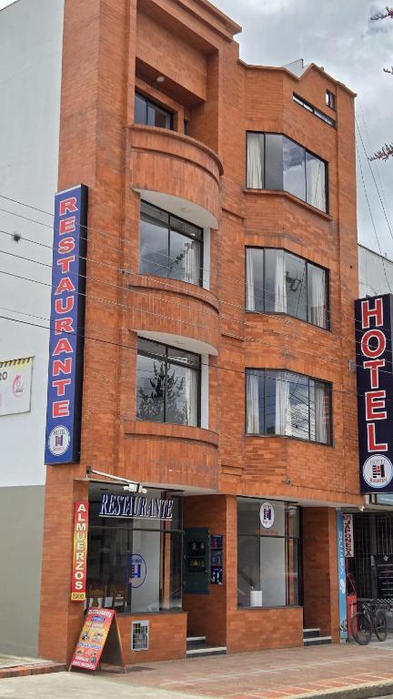 a brick building with a sign in front of it at Hotel Imperial in Chiquinquirá
