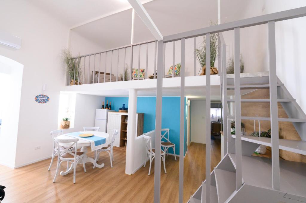 a room with a staircase and a table and chairs at Palanto a Trani in Trani