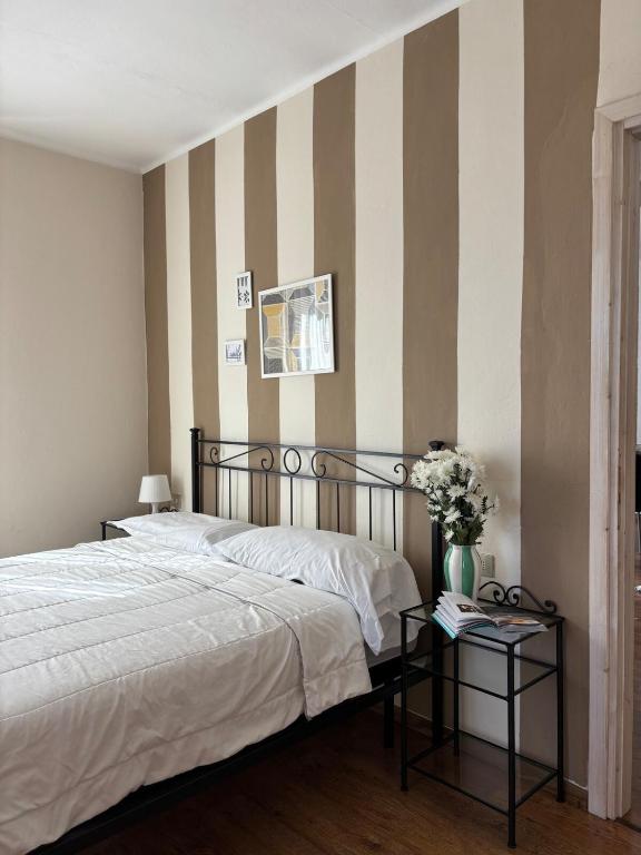 a bedroom with a bed and a striped wall at Charming & bright apartment Como lakefront in Argegno