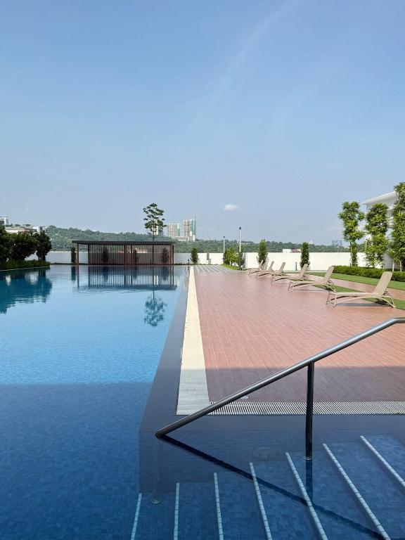 a swimming pool with chairs and water in a building at Suria Garden by Iconique in Puchong