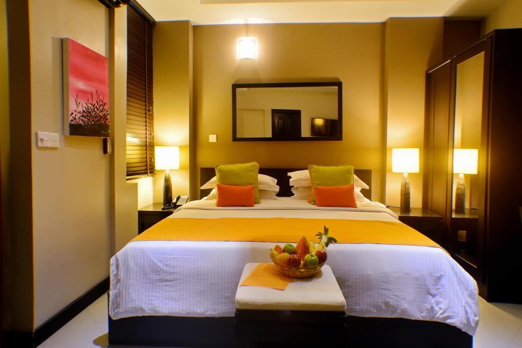 um quarto de hotel com duas camas e um espelho em The Beehive em Malé