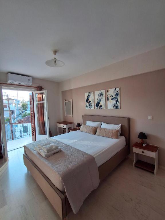 a bedroom with a large bed and a large window at Tasias apartments in Lixouri