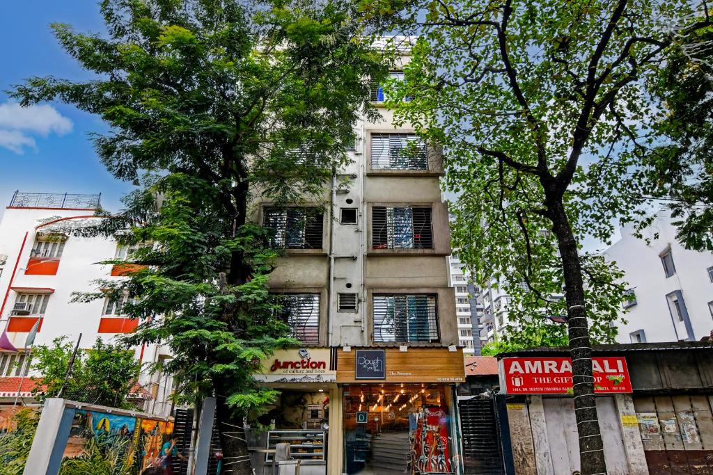a building on a street with trees in front of it at Dream World in Kolkata