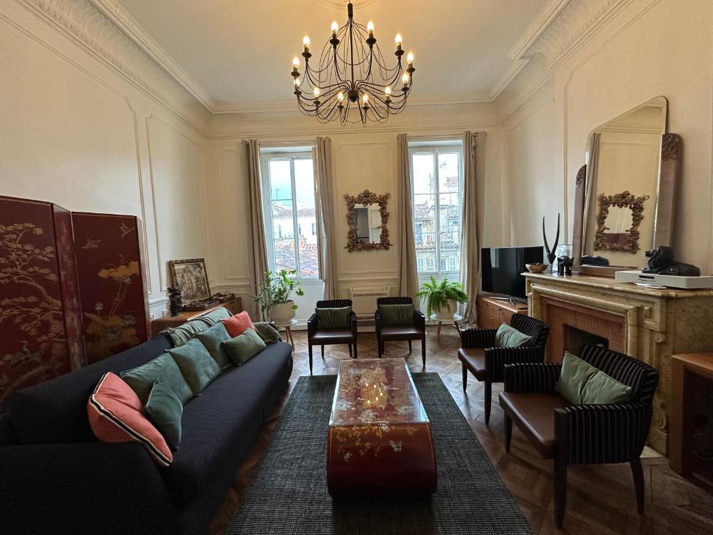 un salon avec un canapé, des chaises et un lustre dans l'établissement Les Floralies Chapitre Canebière, à Marseille