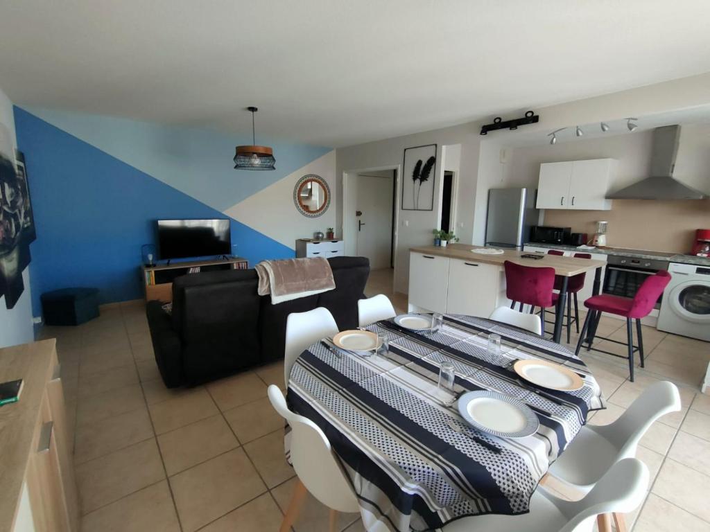 une cuisine et un salon avec une table et des chaises dans l'établissement Appartement T3 équipé idéal curiste avec parking, au Boulou