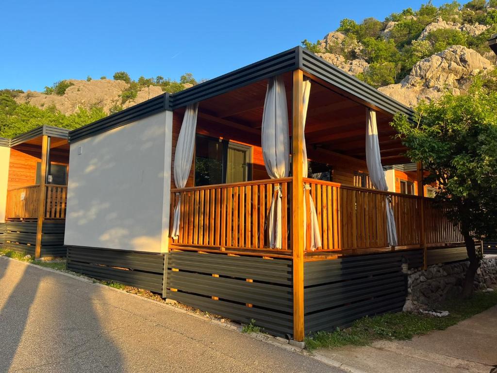 a house with a deck with umbrellas at MIMOSA Luxury Mobile Homes in Sveti Juraj