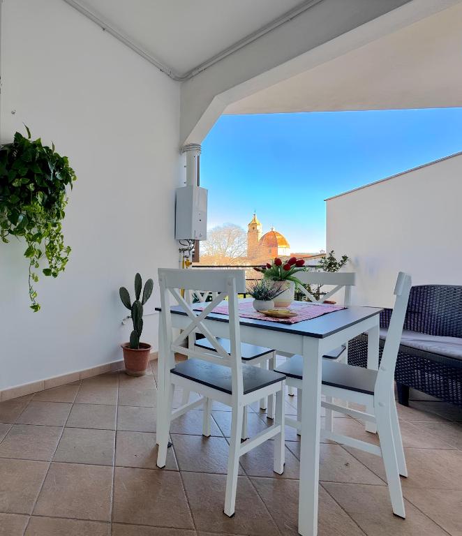 a white dining room with a table and chairs at Orchid House in Bari Sardo