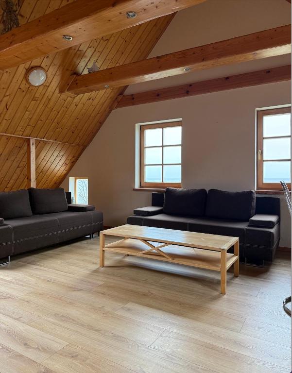 a living room with two couches and a coffee table at Apartamentai Nidoje su vaizdu į marias in Nida