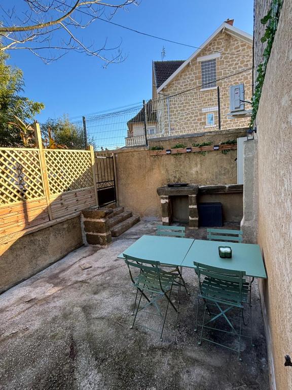 un patio avec une table et des chaises devant une maison dans l'établissement Lesjolislogementsbrivistes exception, à Brive-la-Gaillarde