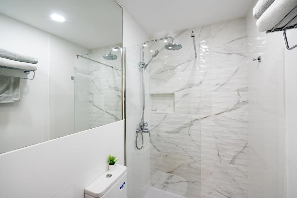 a white bathroom with a shower and a toilet at ABLANCAS - La Restinga in La Restinga