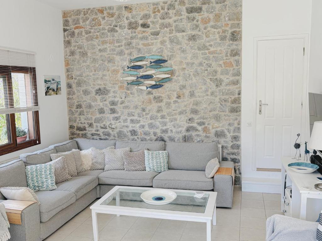 斯基亚索斯镇Skiathos Town House的带沙发和石墙的客厅