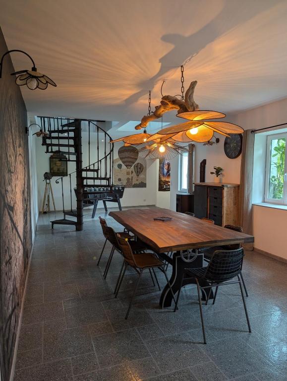une salle à manger avec une table et des chaises en bois dans l'établissement Grand appartement centre ville, à Bellême
