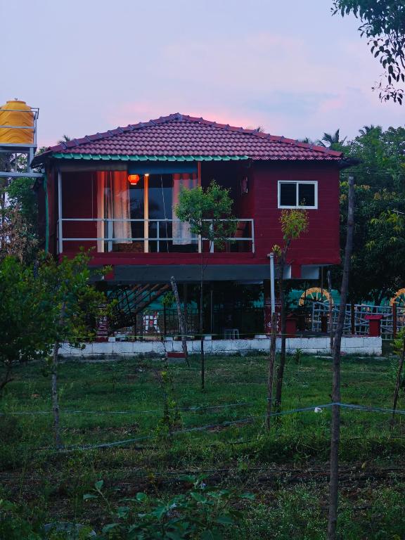 a red house with a red roof at Lalitha Farm Stay in Tumkūr