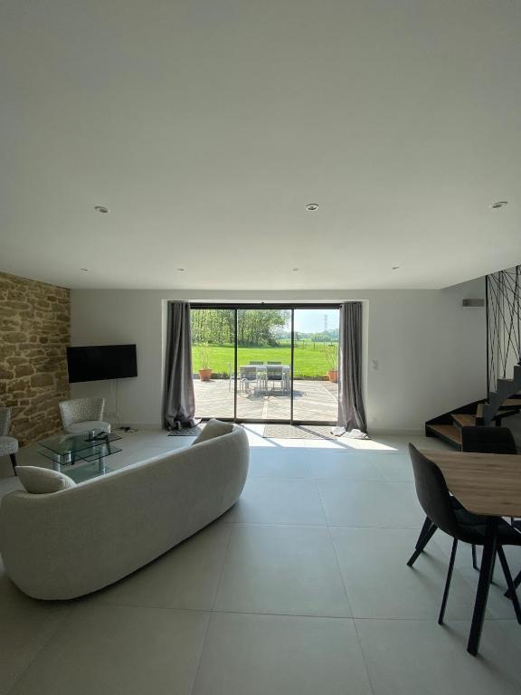 - un salon avec un grand canapé et une table dans l'établissement La maison des prés, à Guérande