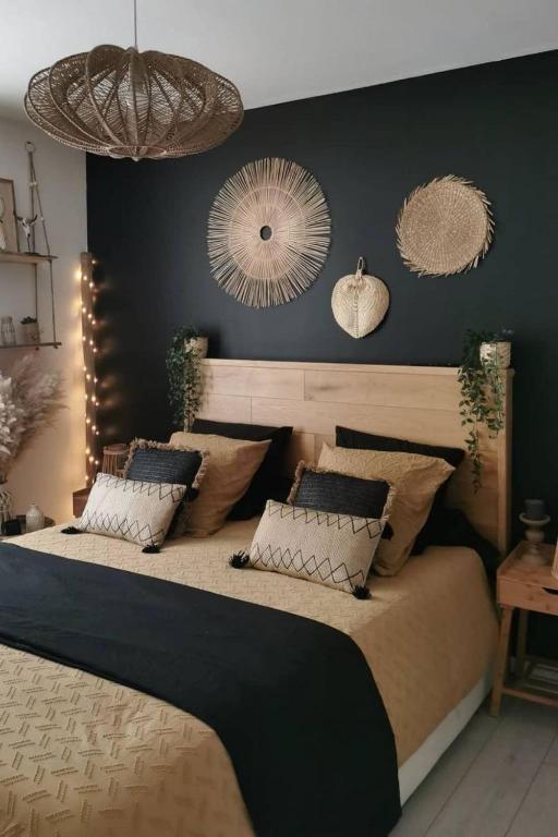 une chambre avec un grand lit avec des murs noirs et des miroirs dans l'établissement L'ébène-Grand T2-Raffiné-en Rez de Chaussée, à Saint-Gaudens