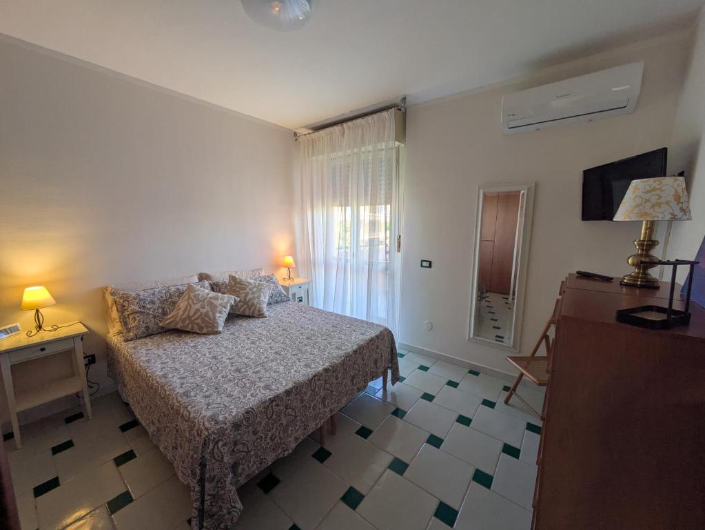 a bedroom with a bed and a table and a television at Orchidea Borghese in Nettuno