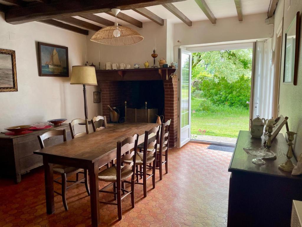 une salle à manger avec une grande table et des chaises en bois dans l'établissement Maison Mirande- Grande maison de campagne familiale entre mer et montagne tout confort très bien équipée, à Guinarthe-Parenties