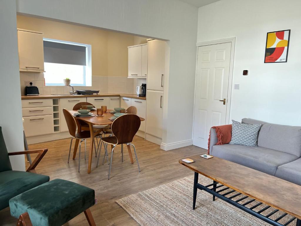 een woonkamer met een tafel en een bank bij The Nest at Amble in Amble
