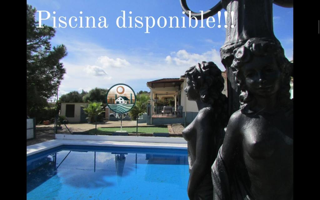 a statue in front of a swimming pool at Villa Alare in Almodóvar del Río
