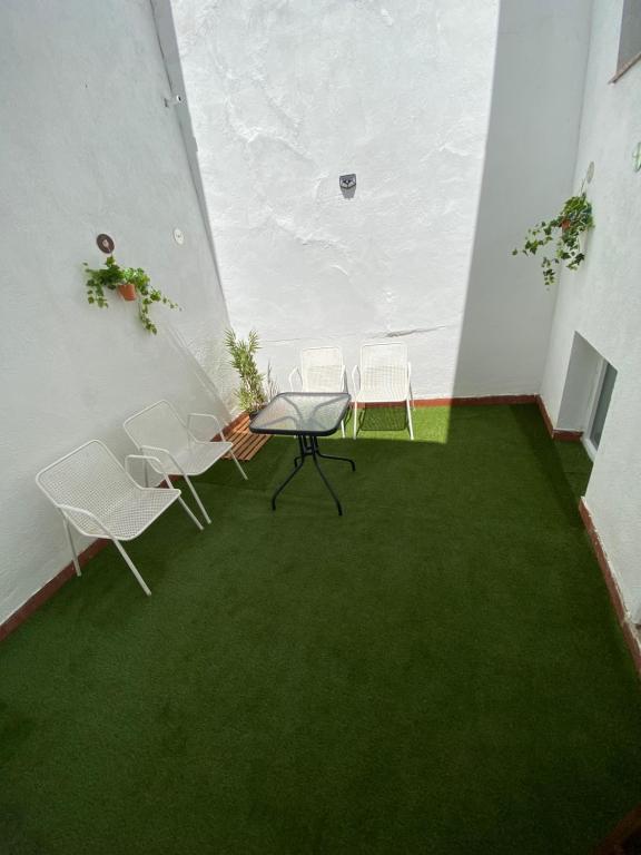 a room with a table and chairs and green carpet at Vivienda rural en Pegalajar in Pegalajar