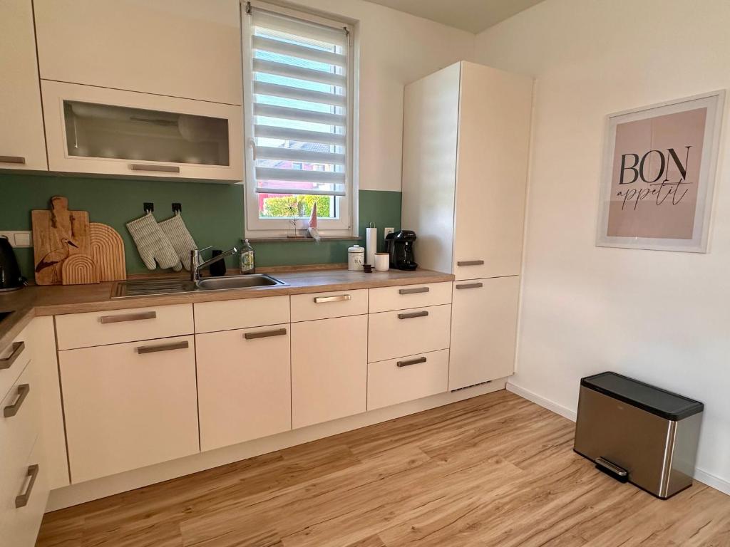 a kitchen with white cabinets and a sink at Ferienwohnung Storchennest in Eisfeld
