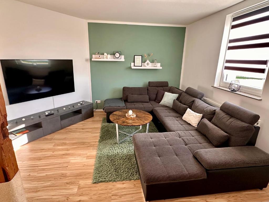a living room with a couch and a tv at Ferienwohnung Storchennest in Eisfeld