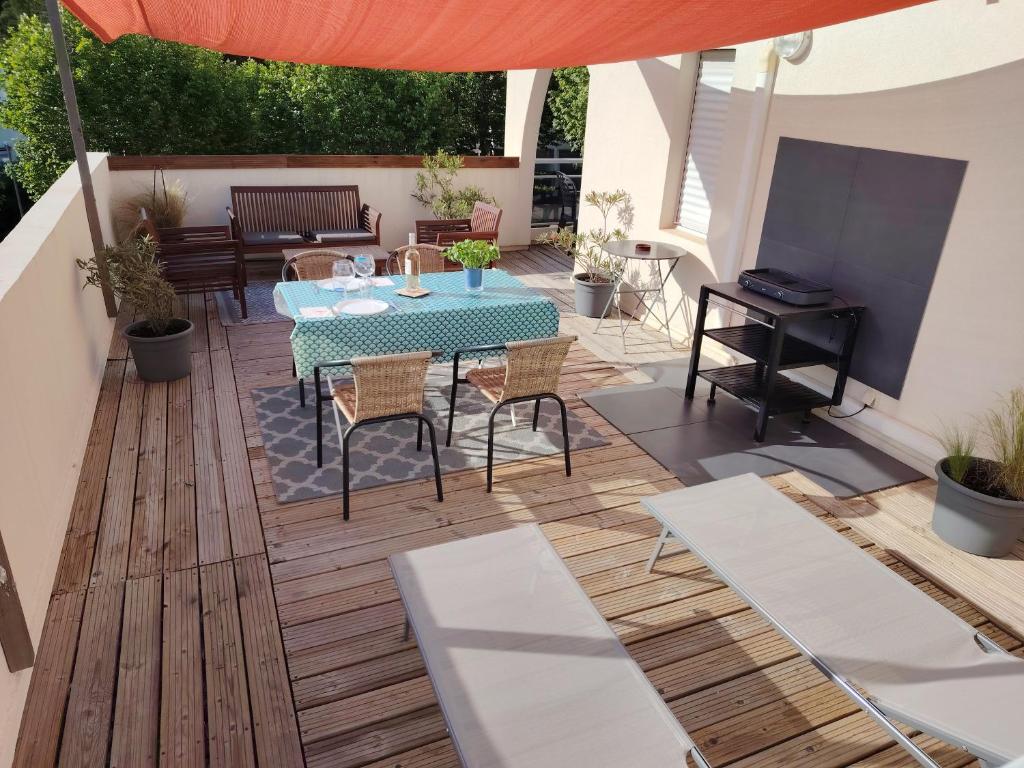 un patio avec une table, des chaises et un parasol dans l'établissement Appartement avec garage et grande terrasse , proximité des plages, à La Grande Motte