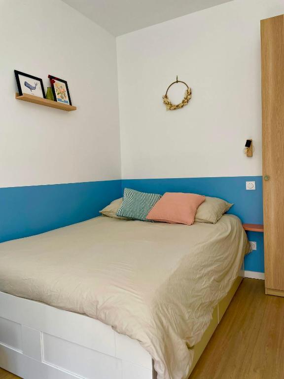 Ce lit se trouve dans un dortoir aux murs bleus et blancs. dans l'établissement Studio centre Rennes, à Rennes