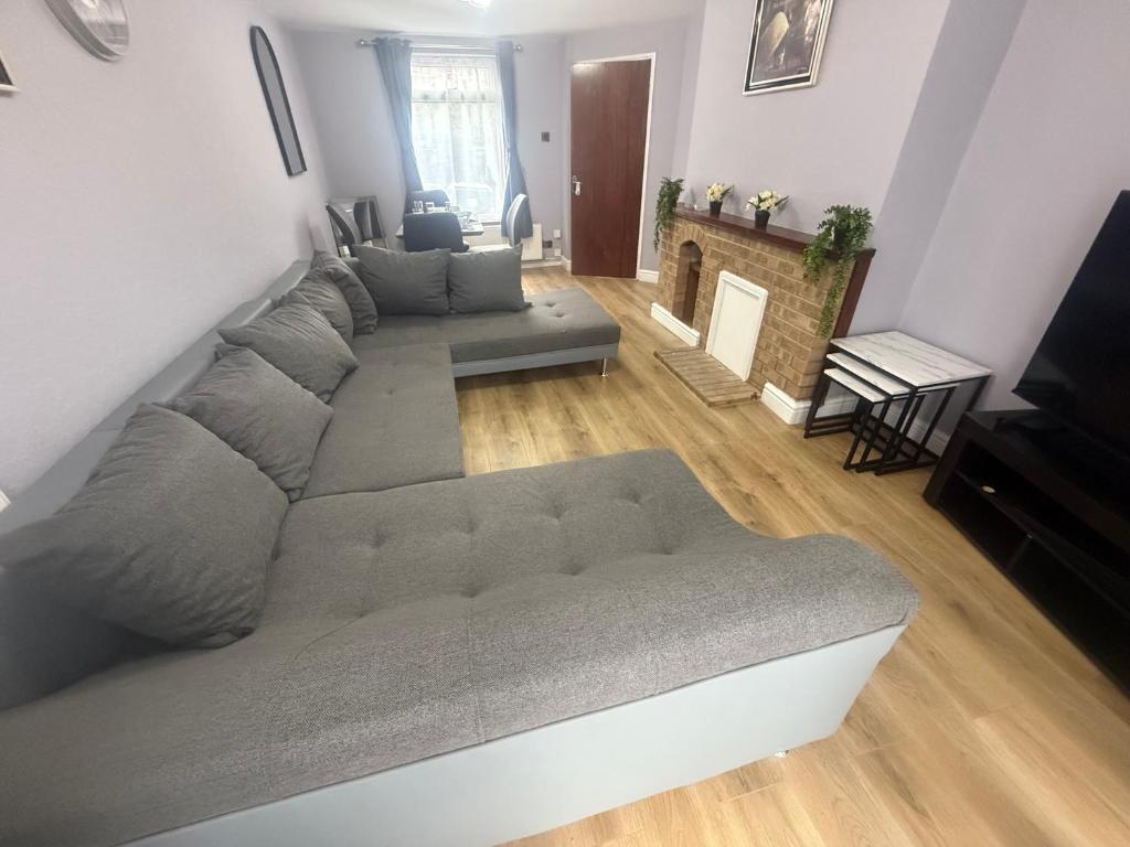 a living room with a couch and a fireplace at D'Luxe Royal 3 bedrooms house in Abbeywood, London in Belvedere
