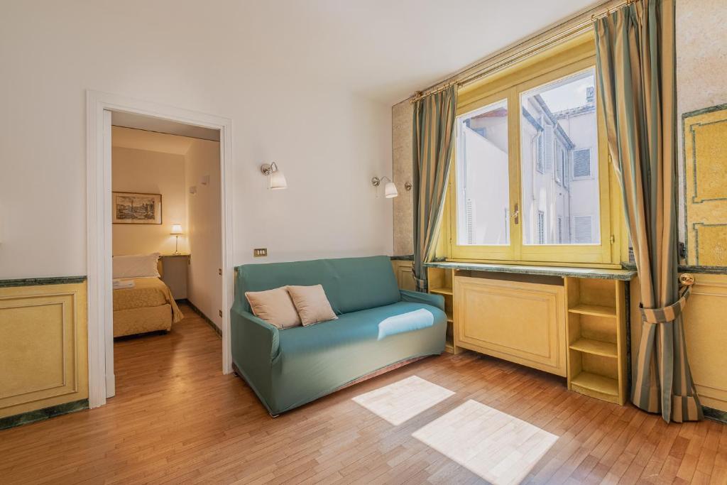 a living room with a blue chair and a window at Elegant apartment inside the Roman Forum in Rome