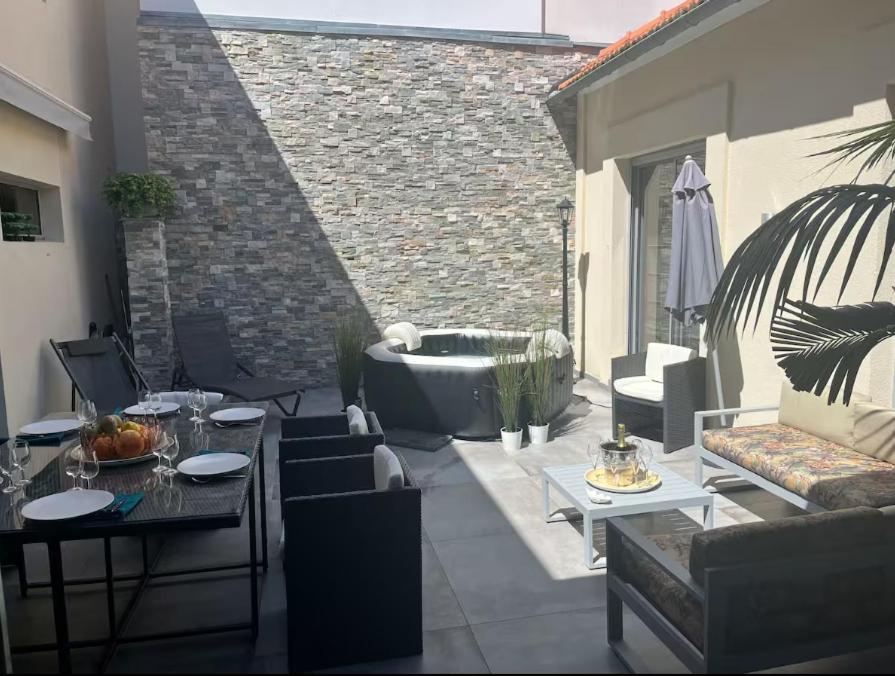 un patio avec une baignoire dans un immeuble dans l'établissement Maison de 250 m2 avec SPA à Arcachon, à Arcachon