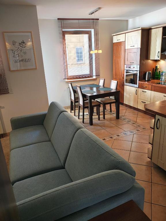 a living room with a couch and a table at Tom & Jerry Apartment - with air conditioning in Głogów