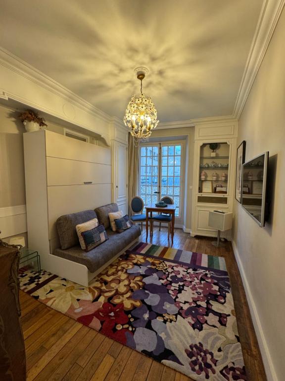 - un salon avec un canapé et un lustre dans l'établissement Studio de charme au coeur de Paris, à Paris