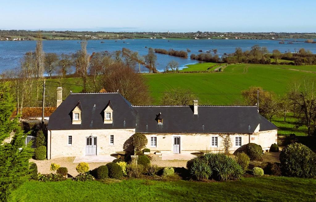 an aerial view of a large white house with a lake at Le domaine des Roseraies, in Monfréville