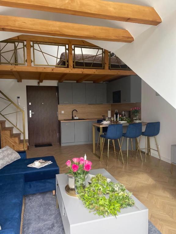 a living room with a couch and a table with flowers at NICE Apartament Głogów in Głogów