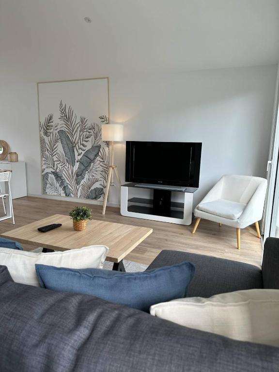 un salon avec un canapé et une télévision à écran plat dans l'établissement Maison neuve entre la Plage, Aréna et de la gare des sables d'olonne, à Les Sables-dʼOlonne