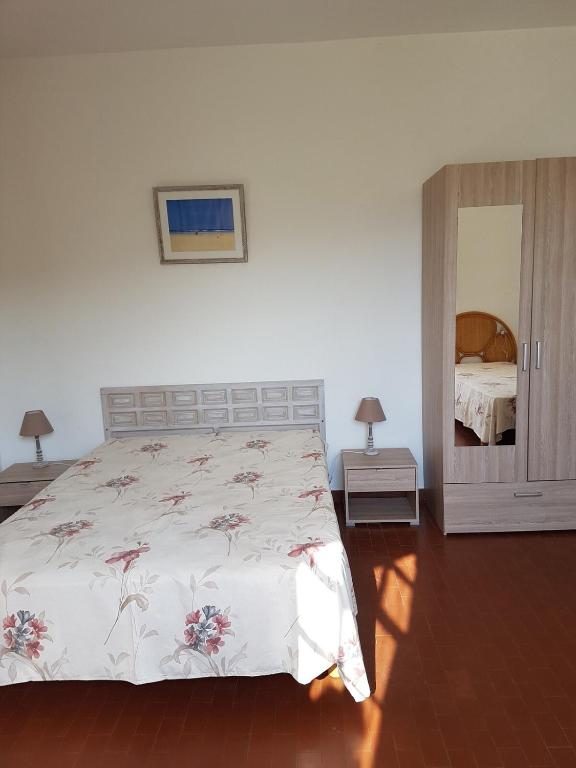 une chambre avec un grand lit et un miroir dans l'établissement Appartement 1 à Regino Speloncato pour 3 personnes, à Speloncato