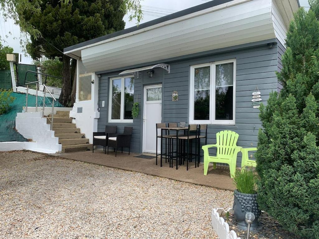 une petite maison bleue avec une table et des chaises dans l'établissement Le refuge du lac, à Changey