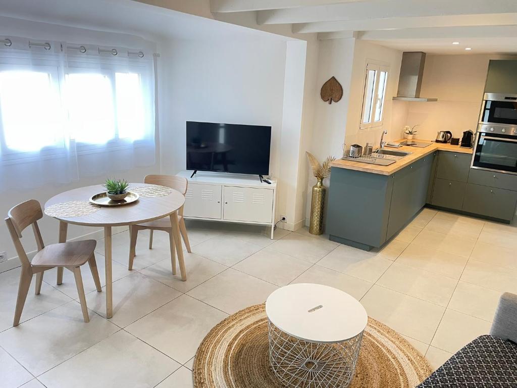 un salon avec une table et une cuisine dans l'établissement Charming Southern house - close center, à Antibes