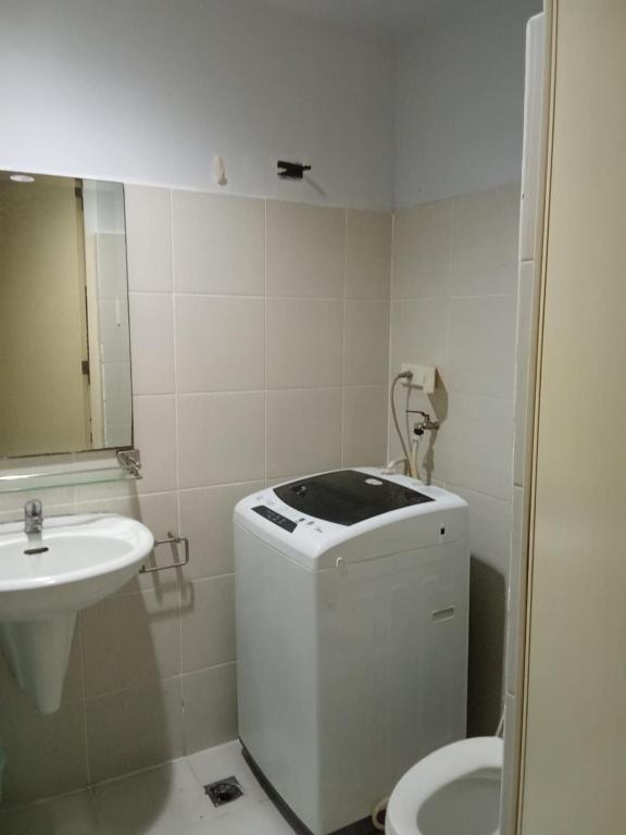 a white bathroom with a sink and a toilet at Sea Residences david in Manila